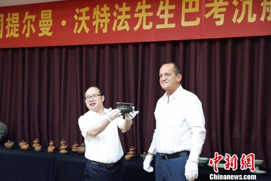 提爾曼-沃特法（右）向湖南省博物館捐贈巴考沉船代表文物明景德鎮(zhèn)窯醬釉三足香爐。湖南省博物館供圖