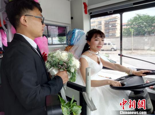 李金可駕駛公交車行駛，丈夫手捧鮮花守護在側(cè)?！≈煨?攝