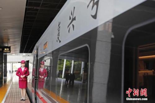 資料圖：4月10日，列車員在“復興號”列車旁迎接旅客的到來。 中新社記者 殷立勤 攝