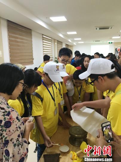 圖為華裔青少年當日在廣西自治區(qū)博物館人員的指導下嘗試拓印一面小的銅鼓。鐘建珊 攝