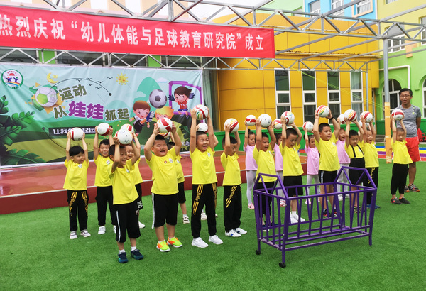 中國關(guān)心下一代工作委員會幼兒體能與足球教育研究院向張家口市懷安縣新區(qū)幼兒園捐贈足球與教材活動現(xiàn)場。