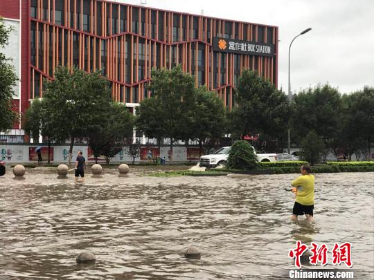 圖為24日上午河北廊坊市區(qū)街頭積水嚴重?！∷蚊魸?攝