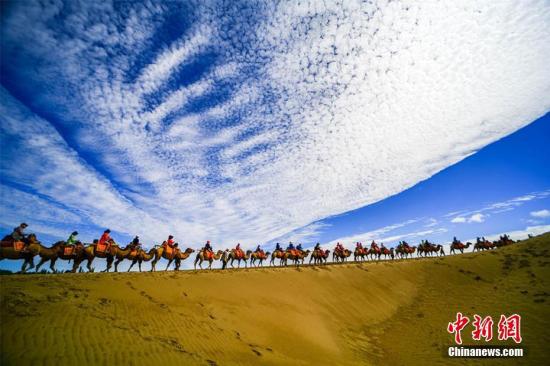 資料圖：甘肅敦煌鳴沙山月牙泉景區(qū)藍天、白云、黃沙相映成趣，每天吸引數萬中外游客觀光游覽。 王斌銀 攝