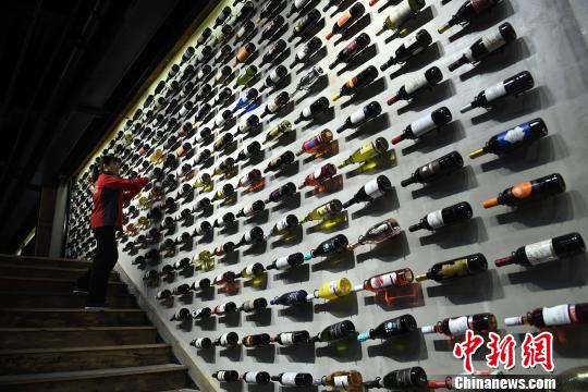 圖為工作人員正在展廳內(nèi)擦拭紅酒瓶?！￡惓?攝