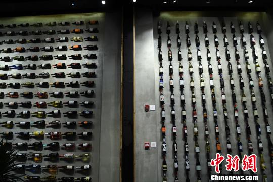 圖為展廳內(nèi)墻壁山掛滿了各類紅酒?！￡惓?攝
