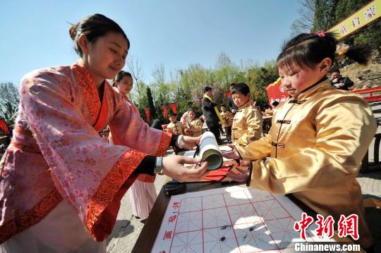 圖為曲阜舉行學(xué)童啟蒙開筆禮儀式?！∏肥形麄鞑抗﹫D 攝