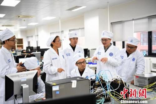 西安分院嫦娥四號探測器的研制人員正在討論問題?！√K宏偉 攝