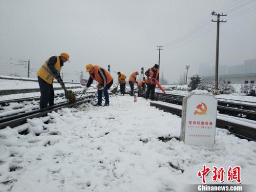 南京東車輛段貨車檢車員風(fēng)雪里按標(biāo)作業(yè)，堅(jiān)守崗位保障運(yùn)輸安全。（劉寅 攝）