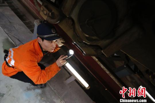 動(dòng)車機(jī)械師正在檢修動(dòng)車車底部件。　丁波 攝