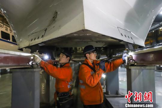 動(dòng)車組機(jī)械師正在檢查動(dòng)車組底部組件?！⌒?攝