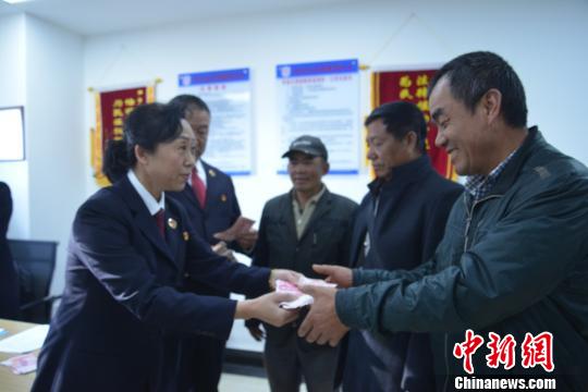 圖為檢察官發(fā)放追討回的農(nóng)民工工資?！∈颈?攝