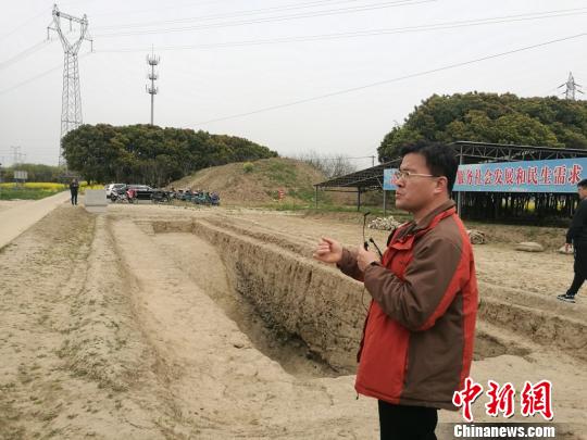 周潤墾在介紹發(fā)掘出的古河道遺址。　鐘升 攝