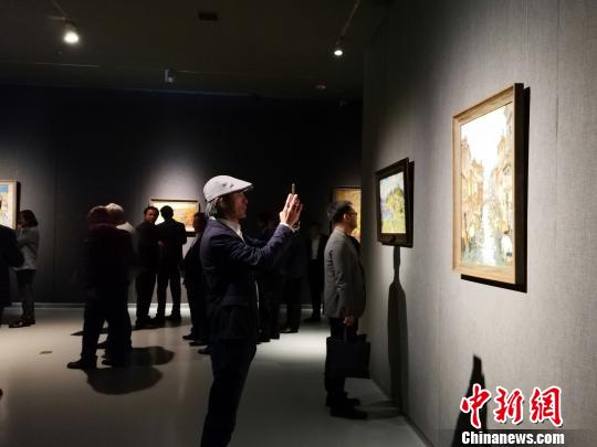 圖為，在“印象山東——俄羅斯油畫家寫生作品展”上，觀眾在喜歡的作品前駐足觀賞、拍照?！O宏瑗 攝