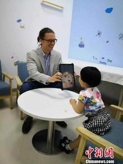 英國專家用AI猴與孩子開心互動。　陳靜 攝