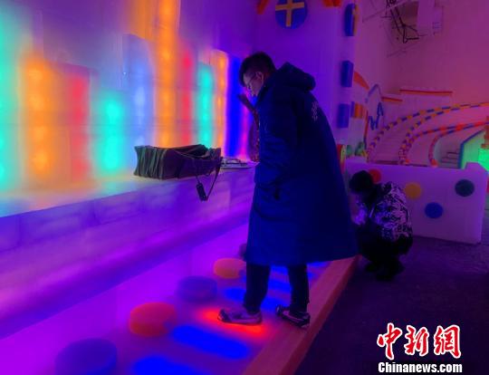 圖為游客正在體驗(yàn)冰鋼琴?！⑿〖t 攝