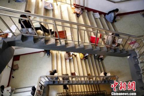 圖為考研生坐在樓梯上專心背誦。　孫宏瑗 攝