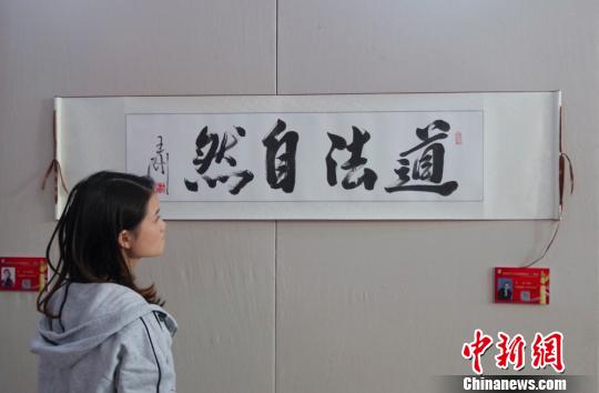 9日，觀眾在“慶祝中華人民共和國成立70周年——影視藝術(shù)家優(yōu)秀書畫作品展”上參觀王剛的書法作品《道法自然》?！?lt;a target='_blank' href='http://www.chinanews.com/'>中新社</a>記者 賈天勇 攝