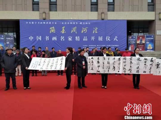 圖為書畫家在中國書畫名家精品開展儀式現(xiàn)場進(jìn)行書法創(chuàng)作，并展示作品。　魯?shù)り?攝