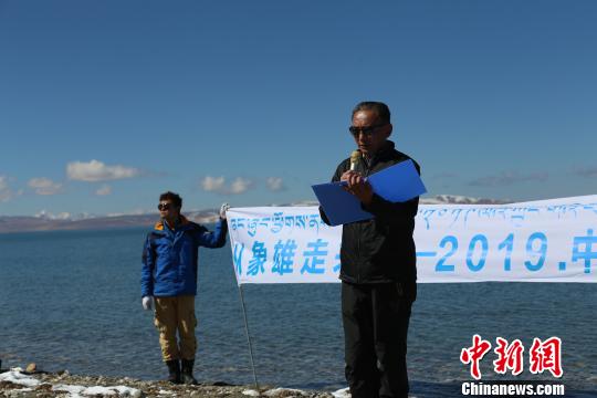 圖為團(tuán)隊成員在瑪旁雍錯湖邊讀詩。活動方供圖