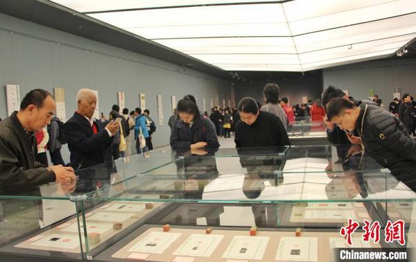圖為觀眾在展廳內(nèi)欣賞篆刻作品?！≮w曉 攝