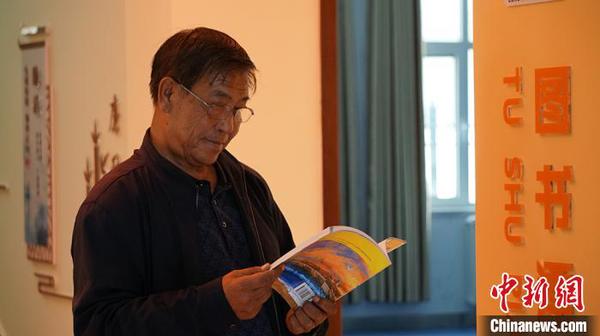圖為社區(qū)居民在圖書漂流站看書?！∥航ㄜ?攝