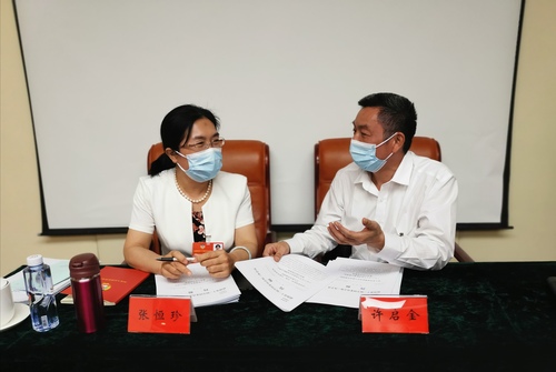 張恒珍委員（左）和許啟金委員在交流各自提案。 特邀委員記者 皮劍龍 攝
