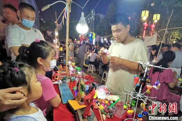 資料圖：圖為手工藝人在夜晚走上街頭，展示面塑工藝。　趙曉 攝