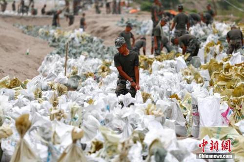 資料圖：7月25日，江西省九江市柴桑區(qū)江洲鎮(zhèn)北堤，中國(guó)人民解放軍第71集團(tuán)軍某部官兵正在為防洪備料。