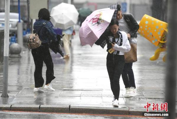 資料圖：市民頂風(fēng)冒雨出行。 中新社記者 張瑤 攝