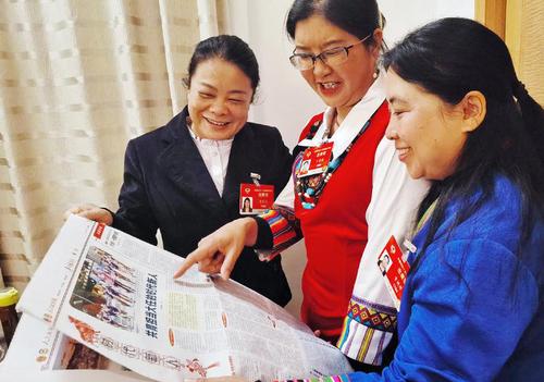 住滇全國政協(xié)委員黃麗云、丁秀花、資艷萍（從左至右）閱讀人民政協(xié)報，就更好的培養(yǎng)孩子們成為新時代接班人等教育問題各抒己見。 特邀委員記者 茸芭莘那 攝