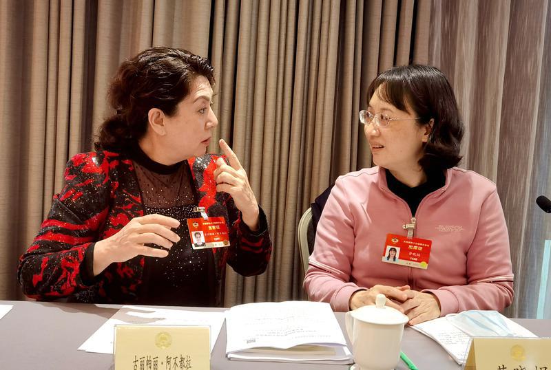 古麗帕麗?阿不都拉委員（左）和黃曉娟委員就提案各抒己見。 特邀委員記者 唐江澎攝