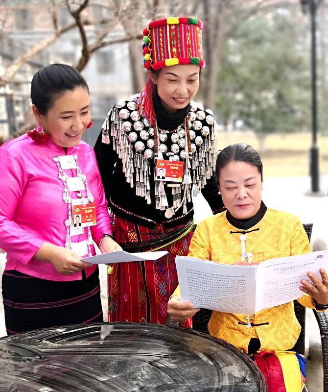 少數民族界楊艷、何慶、黃麗云三位委員（從左至右）就全國政協常委會工作報告中共同關注的話題進行交談。特邀委員記者 資艷 萍 攝